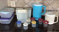Photo showing the full selection of the plastic containers and pitchers on a kitchen counter with tiled backsplash