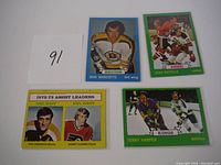 Four 1973 Topps hockey cards including Don Marcotte, Jean Ratelle, Terry Harper, and 1972-73 Assist Leaders card showing Phil Esposito and Bobby Clarke.