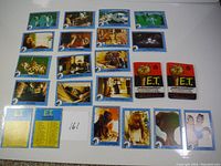 Full set of 12 blue-bordered trading cards featuring scenes from E.T. and two unopened card wrappers.