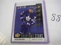 2019-20 Upper Deck Shooting Stars hockey card featuring Auston Matthews in Toronto Maple Leafs uniform, in protective case, front view.