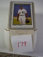 Top view of Frank Thomas rookie card in clear protective case on top of a white box with handwritten '179' on front.