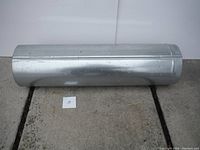 Metal ductwork section, cylindrical approx 30" long, placed on a surface
