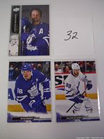 Photo showing three Toronto Maple Leafs hockey cards: Auston Matthews portrait card, Mitch Marner in blue uniform skating, and William Nylander in white uniform skating.