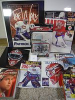 Photo showing entire Patrick Roy collection including framed signed photo, figurine, magazines, and books