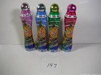 Front view of four colorful Dab Ink Sun Sational bingo dabbers showing their labels and diamond-patterned caps.