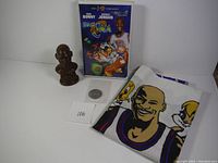 Photo showing the full set: Space Jam VHS tape, ceramic bust, collectible coin, and Michael Jordan pillowcase