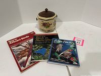 Photo of three bird-related books alongside a Japanese decorative ceramic canister with floral design and wood top.