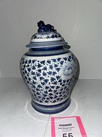 Front view of the small Chinese blue and white jar and its lid with sculpted figure.