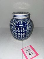 Front view of the porcelain ginger jar with Double Happiness symbol and floral design. Jar placed on white surface with size reference card.