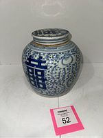 Front view of 19th century Chinese stoneware ginger jar with blue double happiness calligraphy symbol and floral decoration on white ground.