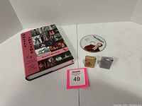 Photo showing the hardcover theater book, Curb Your Enthusiasm CD, and two collectible lighters on a white background.