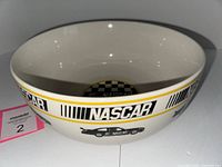 Side view of white ceramic NASCAR serving bowl showing NASCAR logos and race car designs on the exterior.