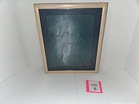 Front view of the framed nude sketch on blue paper showing the full artwork and frame.