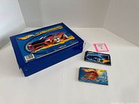 Blue Hot Wheels carrying case and two spiral-bound Hot Wheels catalogs with car cover art.