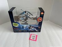 Photo of boxed GyroPter Propel three-channel remote control helicopter targeting ages 14 and up, showing front and side box sides with visible toy inside.