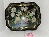Front view of large metal serving tray with tulip bouquet painting and gold trimmed scalloped edges.