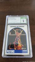 Frontal photo of Dennis Rodman 1989-90 NBA Hoops basketball card encased with CSG 9 Mint grade label visible showing card number #211 and player image.