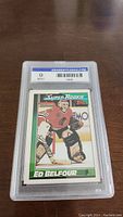 Front view of Ed Belfour rookie graded hockey card in protective plastic case with label GradeMyCards.com graded 9 Mint