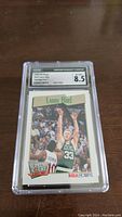Front view of the Larry Bird Supreme Court basketball card graded by CGC at 8.5 in protective casing showing the player image and branding.