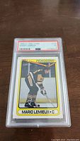 Front of 1990 O-Pee-Chee Mario Lemieux hockey card in graded PSA slab showing the player skating in Pittsburgh Penguins uniform