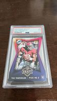 Front of 2020 Panini Instant Draft Night Tua Tagovailoa rookie football card graded PSA 7, showing player in action with card details and PSA label.