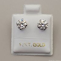 Close-up image of earrings mounted on white card with 10K gold stamp visible.