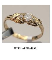 Close-up of ring showing three-stone setting and diamond details