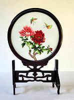 Front view of the circular framed table screen showing embroidered silk with floral and butterfly design on rosewood stand