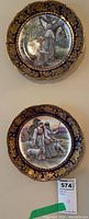 Two Hammersley & Co. china collector plates mounted on a wall, showing full front view with detailed painted scenes and ornate borders.