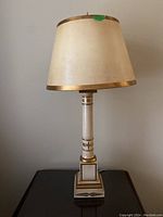 Table lamp unlit showing cream shade with gold trim and cream/gold base
