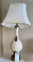 Full view of the mid-century modern ceramic table lamp including lampshade and metal base, showing overall condition and design.