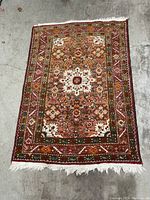 Top-down photo of rectangular rug with oriental pattern, showing wear and discoloration.