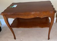 Full view of wooden side table showing top surface and curved legs