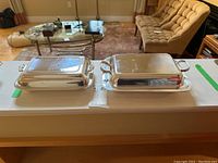 Two silverplate covered serving dishes shown from an angled side view.