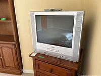 Front view of Toshiba 20-inch CRT TV with DVD player on wooden cabinet.