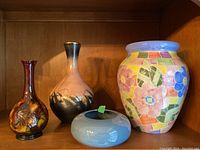 Four items: Moorcroft floral vase with chip, pink and black abstract slender vase, large floral mosaic vase, light blue glass bowl with hollow center.