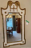 Full view of the framed wall mirror mounted on a wall in a dining room setting showing overall design and scale.