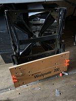 Folded Black & Decker Workmate 200 workbench showing wooden clamping surface and black metal frame with orange clamps.