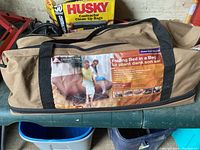 Camping bed in its carry bag, displaying the Oceans Trail brand label and product features.