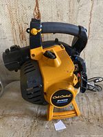 Photo of yellow and black Cub Cadet BV282 gas powered leaf blower with handle, engine, and blower tube visible.