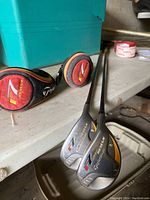 Two Taylormade 7 Rescue golf clubs labeled 3 and 4 with protective headcovers placed on a surface.