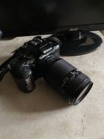 Photo of Nikon F-401x camera body with Nikon 35-70mm zoom lens attached placed on surface with monitor in background