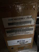 Label on box showing brand Weatherby, size 24x48 inches, 2 inch cream blinds, barcode and product codes.