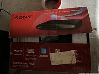 Photo of Sony DVD player box showing model DVP-SR510H and features like 1080p HDMI upscaling.