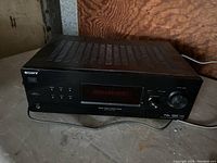 Sony STR-DH130 stereo receiver photographed from the front and slightly above showing the top view with ventilation slots and front panel knobs, digital display, and headphone jack.