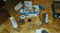 Full view of costume jewelry lot including necklaces, bracelets, earrings in boxes, and other jewelry items on floor.