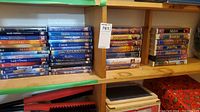 Photo showing a collection of Disney VHS tapes arranged in wooden shelf, titles include Pocahontas, Bambi, Aladdin, The Lion King, Sleeping Beauty among others