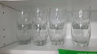 Eight short rock glasses with faceted design on a shelf