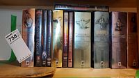Photo showing Highlander DVD collections, including multiple box sets and individual DVDs lined up on a shelf; decorative slipcases with Highlander characters visible