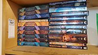 Top view showing 11 Stargate SG-1 DVD box sets seasons and 6 MacGyver DVD cases including TV movies.